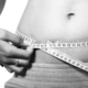 reduce stubborn fat - woman measuring waist