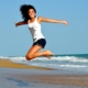 woman jumping on beach benefits of red light therapy
