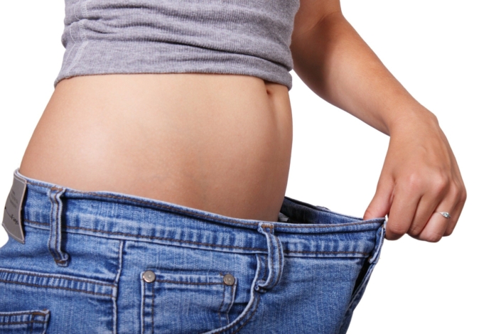 woman with big jeans - health benefits of weight loss