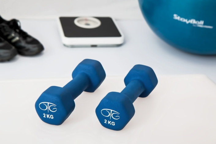 dumbells and scale - benefits of weight loss